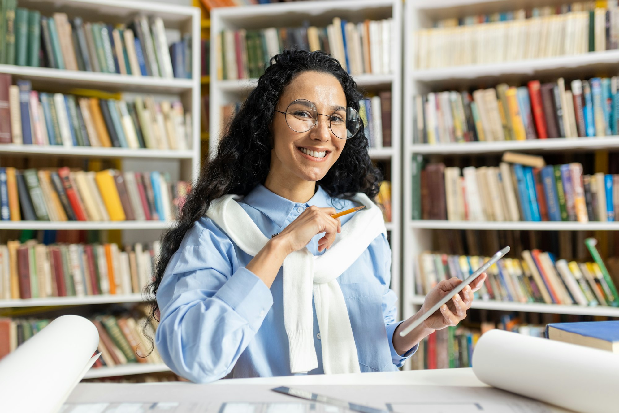 Happy researcher using smartphone in a library setting